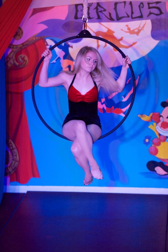 Performer seated inside a lyra aerial hoop at Orlando Circus School